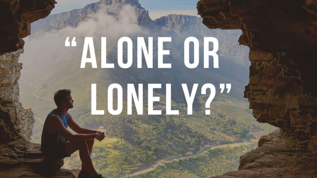 man sitting, looking out of cave area up in hilly mountain